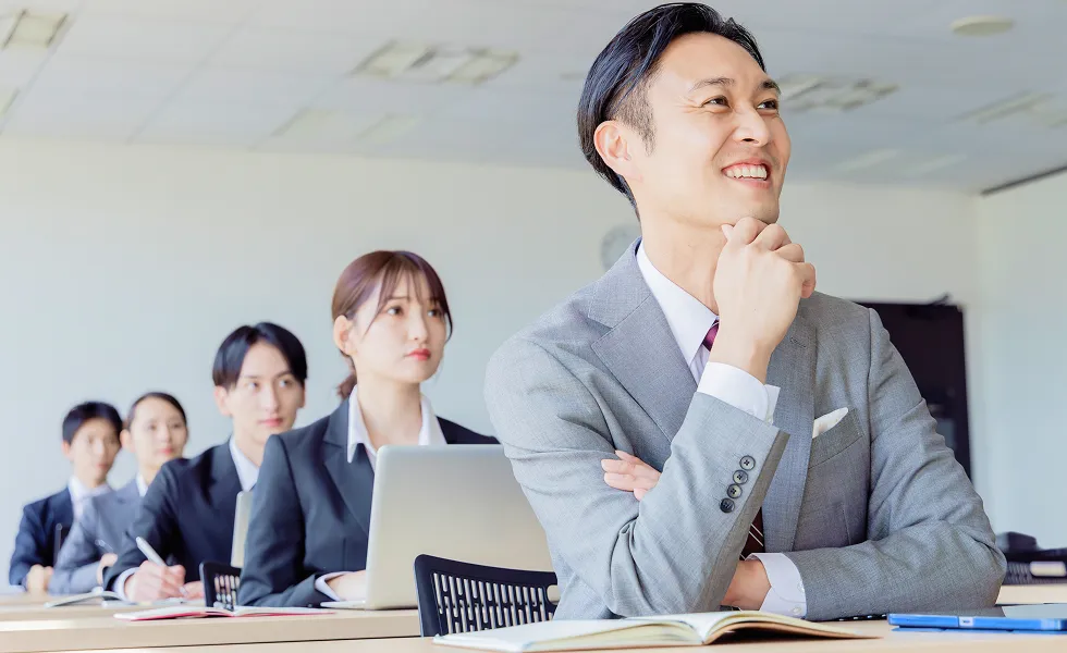 研修を受けながら前向きな表情で考えるスーツ姿のビジネスパーソン
